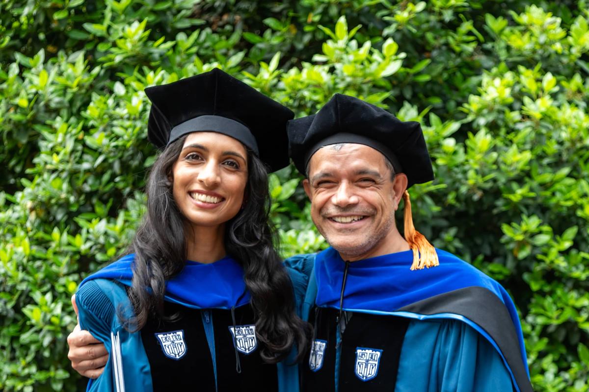 man and woman in caps and gowns, woman with diploma