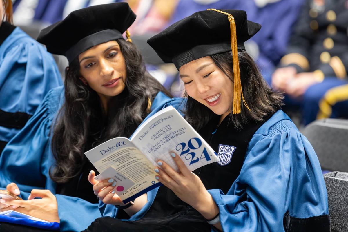 Two woman looking a the program carefully