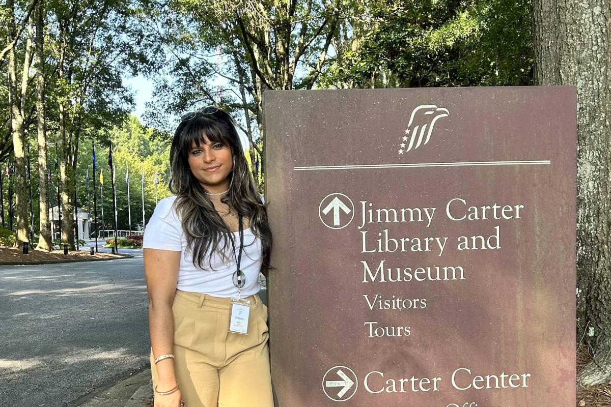 Woman standing by Jimmy Carter Library and Museum sign