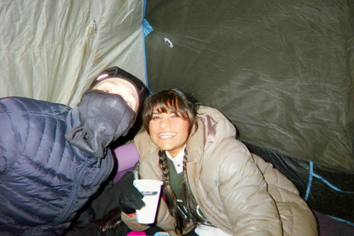 Camping out, two people in a tent, looking like they are having fun