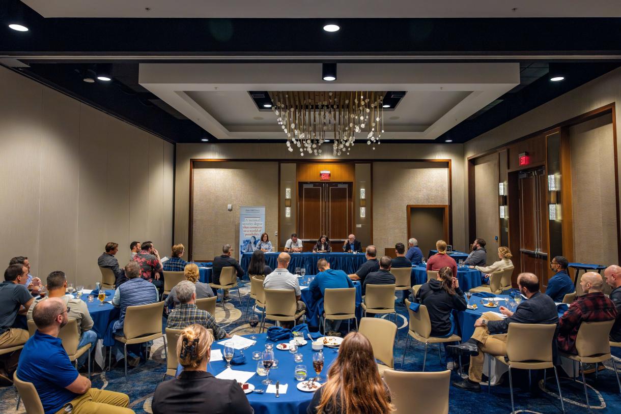 Picture of entire dinner room with panelists in the center back