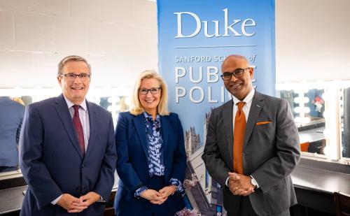 Cheney flanked by two men and the Duke Sanford public policy sign