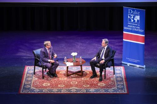 Two men chatting on stage each sitting in chairs