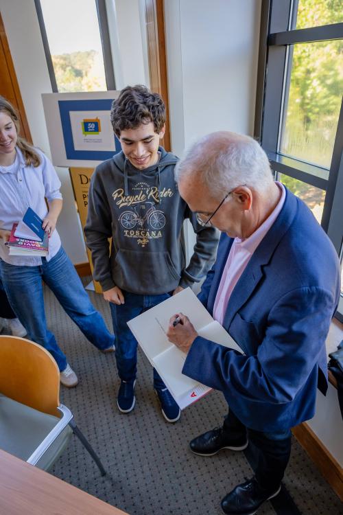 Brooks signing books for eager students