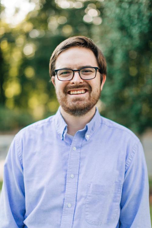 Man with glasses and beard, smiling