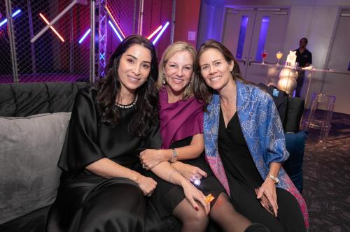 Three women smiling at camera at party