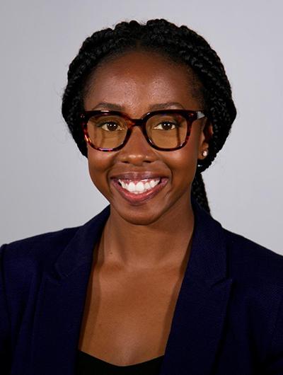 Woman with glasses smiling at camera for headshot