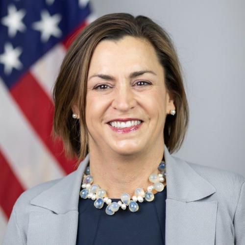 Woman smiling at camera, with American Flag in the backgroun