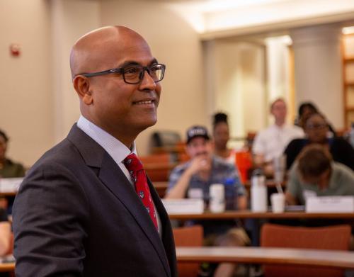 Man with red tie, smiling in front of class